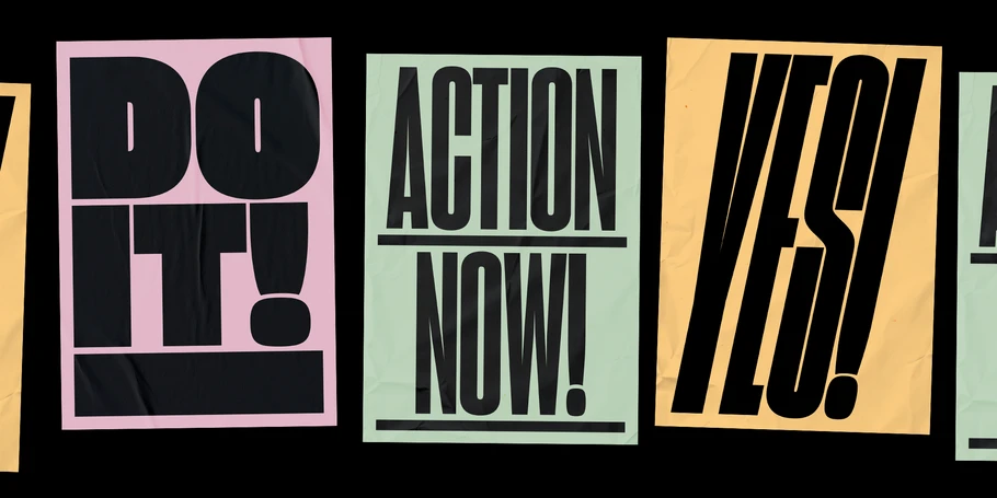 Five signs (three in frame) in pink, green, and yellow with the following text, respectively: "DO IT! ACTION NOW! YES!"
